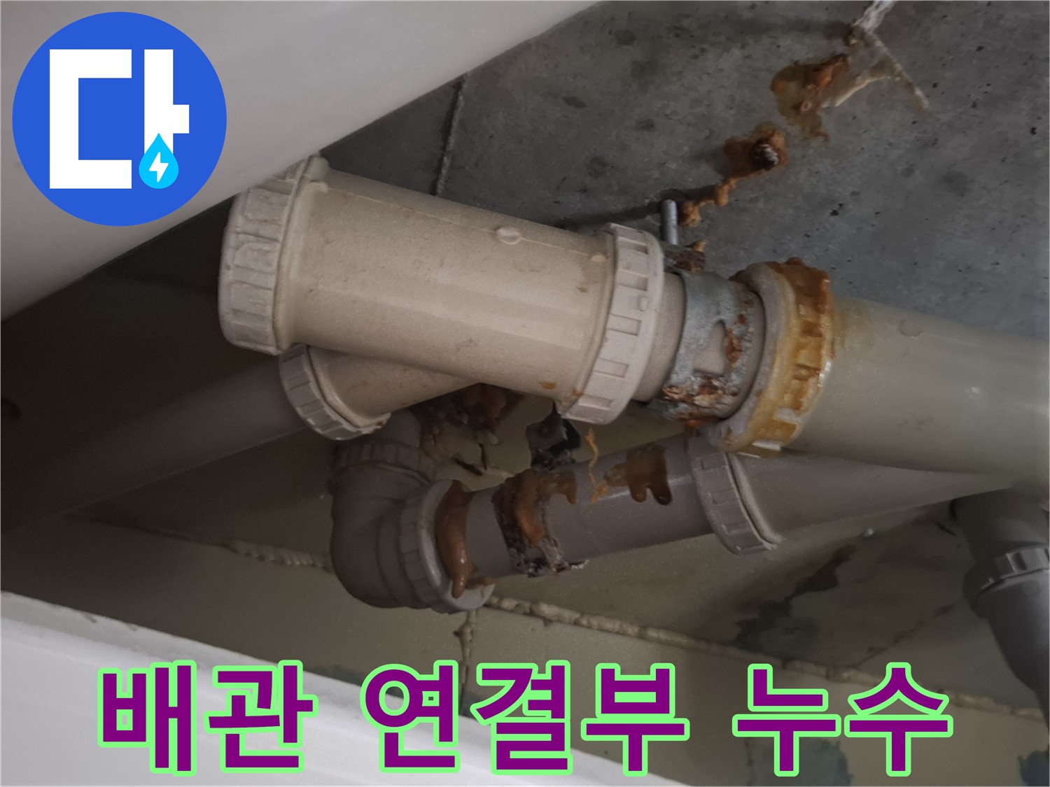 배관 연결부 누수 - 하수 배관 연결 부위에서 물이 새어 나오는 것을 보여주는 사진입니다.