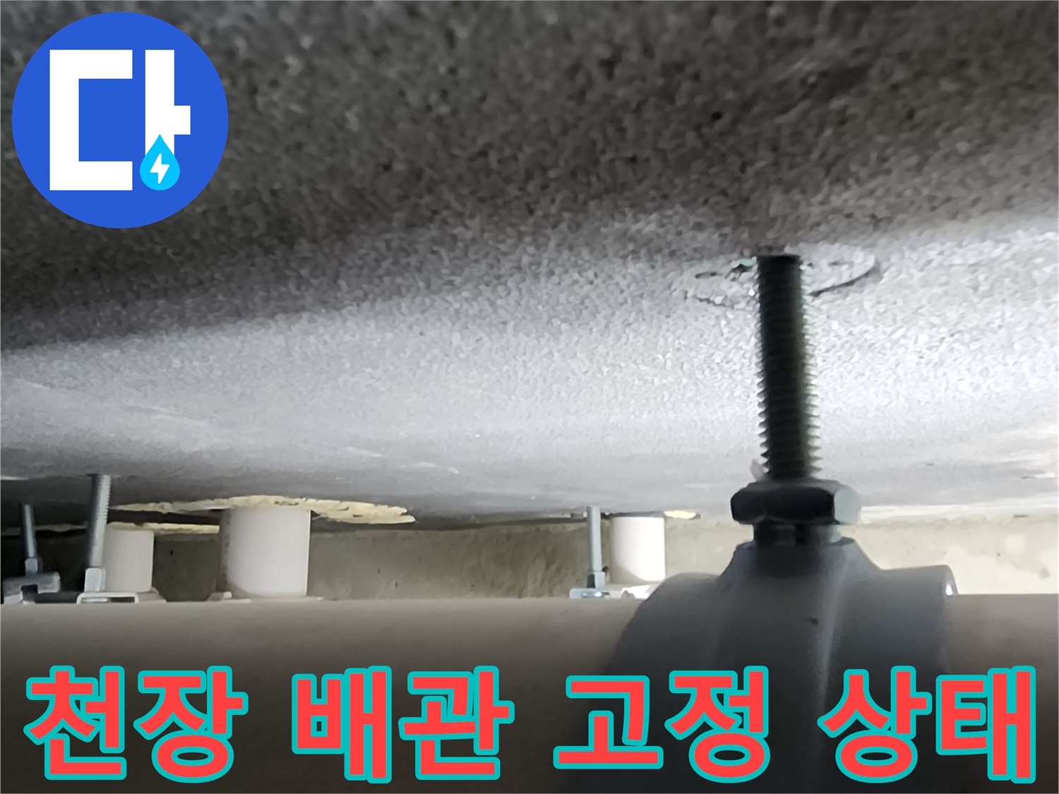 천장 슬래브에 고정된 배관 지지대와 볼트 모습