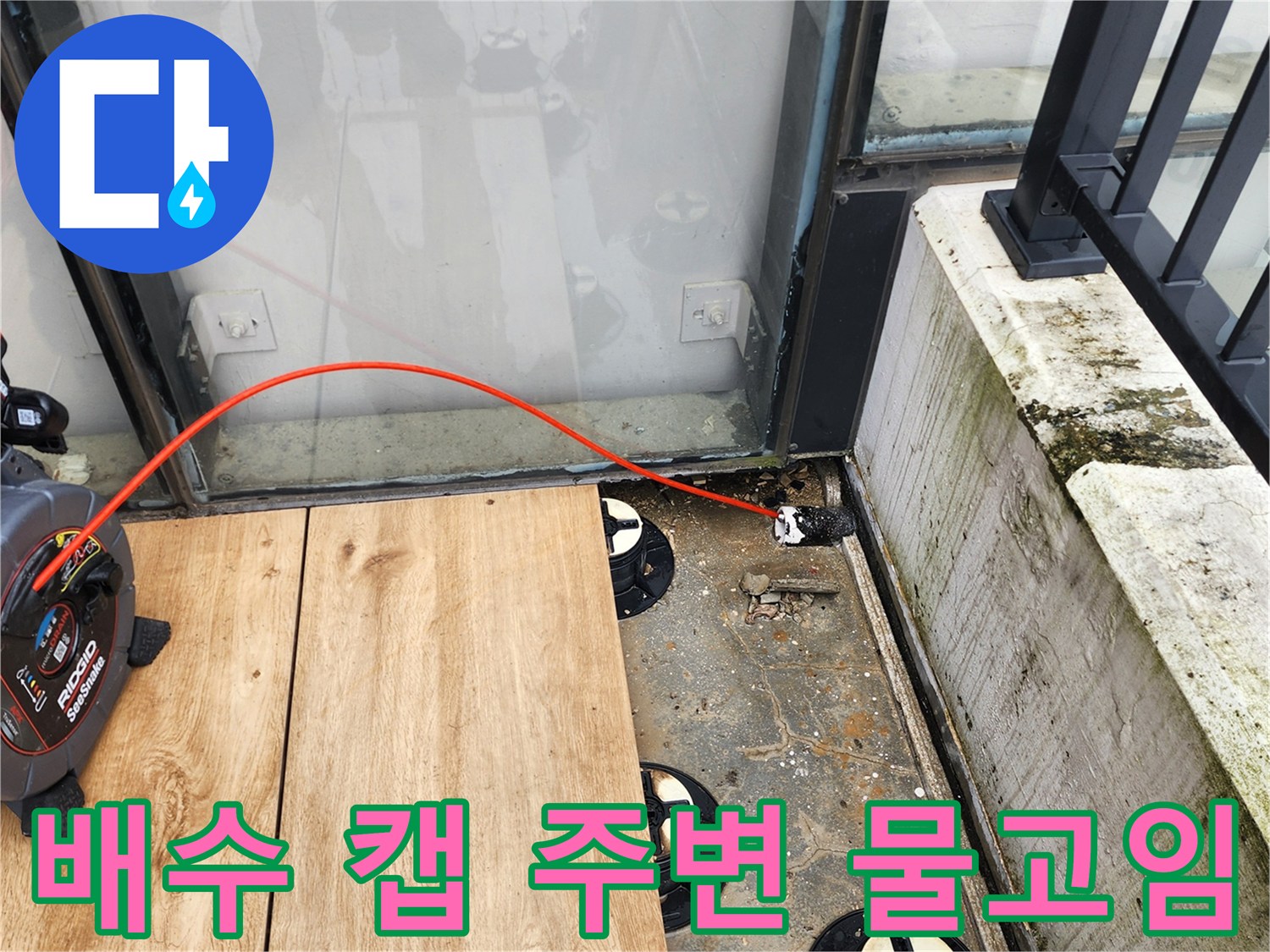 데크 아래 배수 캡과 고인 오염물을 보여주는 사진입니다.