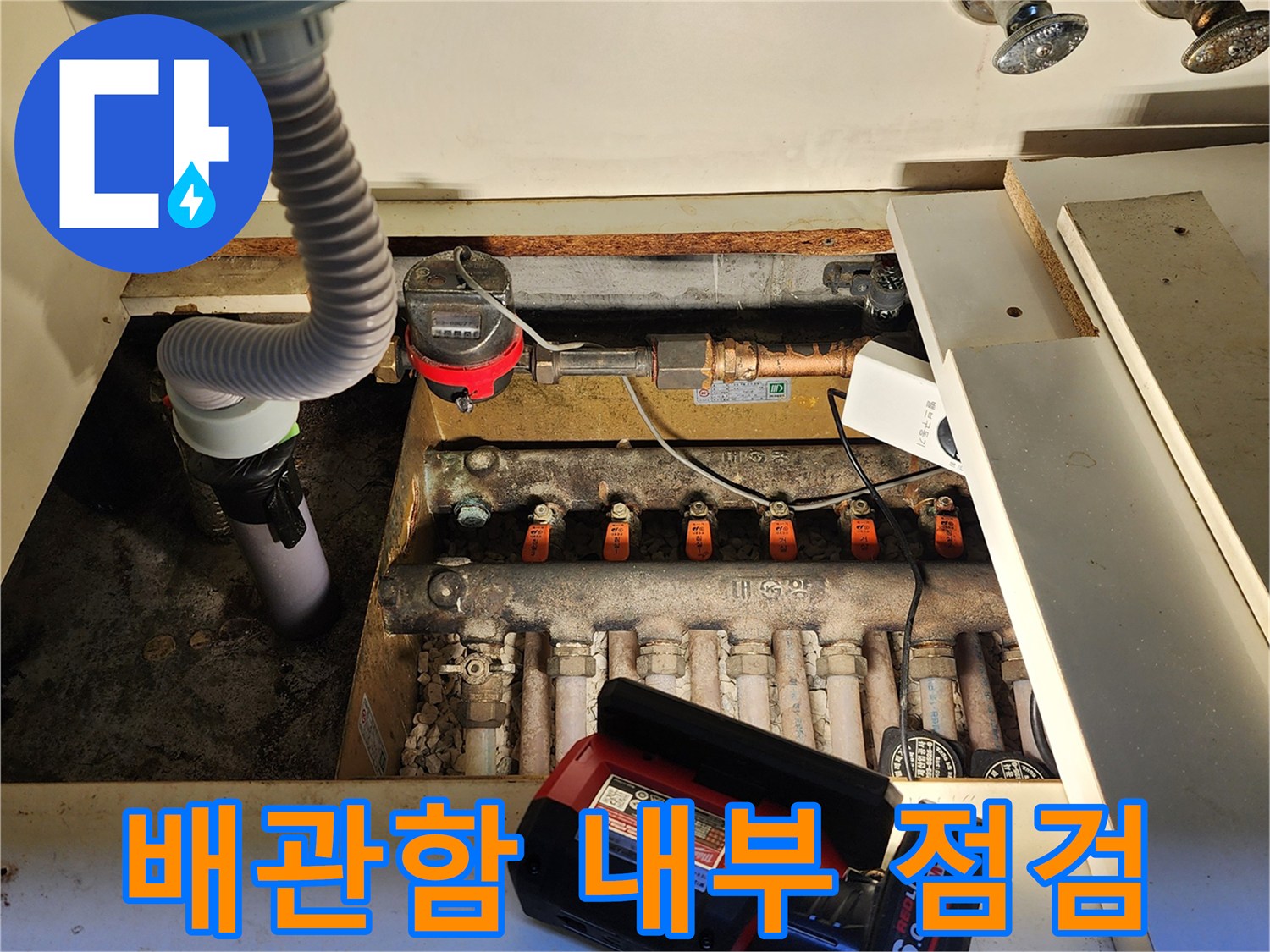 싱크대 아래 수도 계량기와 밸브가 설치된 배관 함의 모습