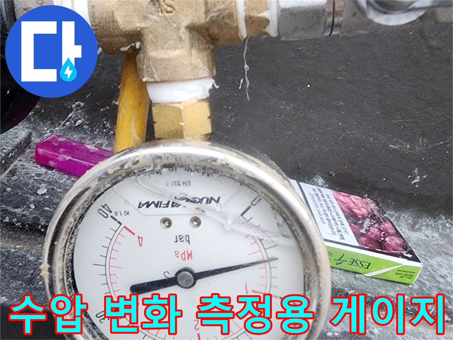 금속 부속과 연결되어 수압을 표시하고 있는 아날로그 압력계