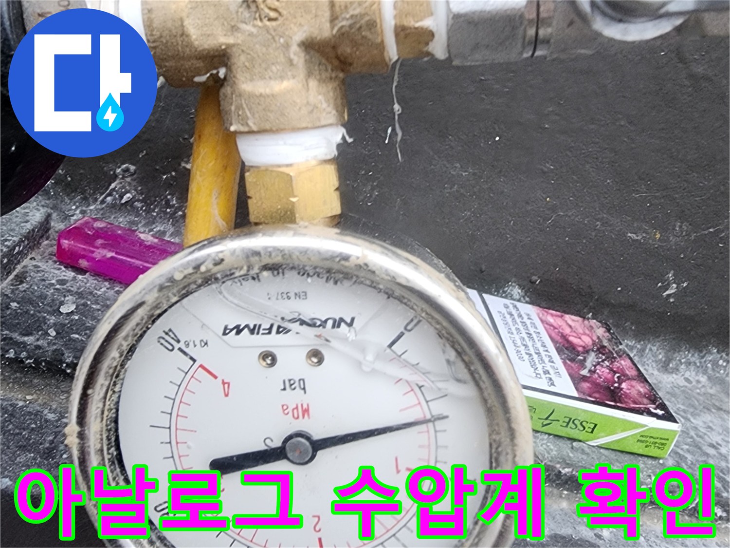 금속제 배관 연결부와 숫자가 적힌 아날로그 압력계