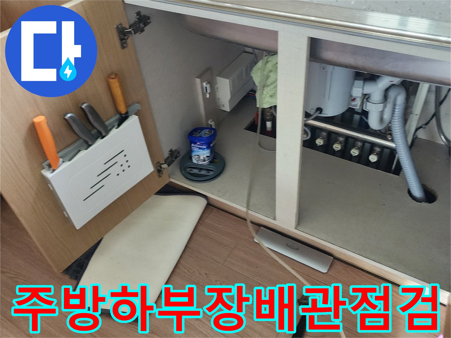 싱크대 하부장 내부의 배관 연결 부위와 바닥 상태