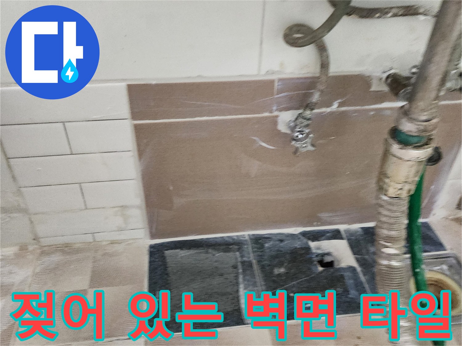 물기가 스며든 세탁실 벽면 타일과 노출된 급수 호스