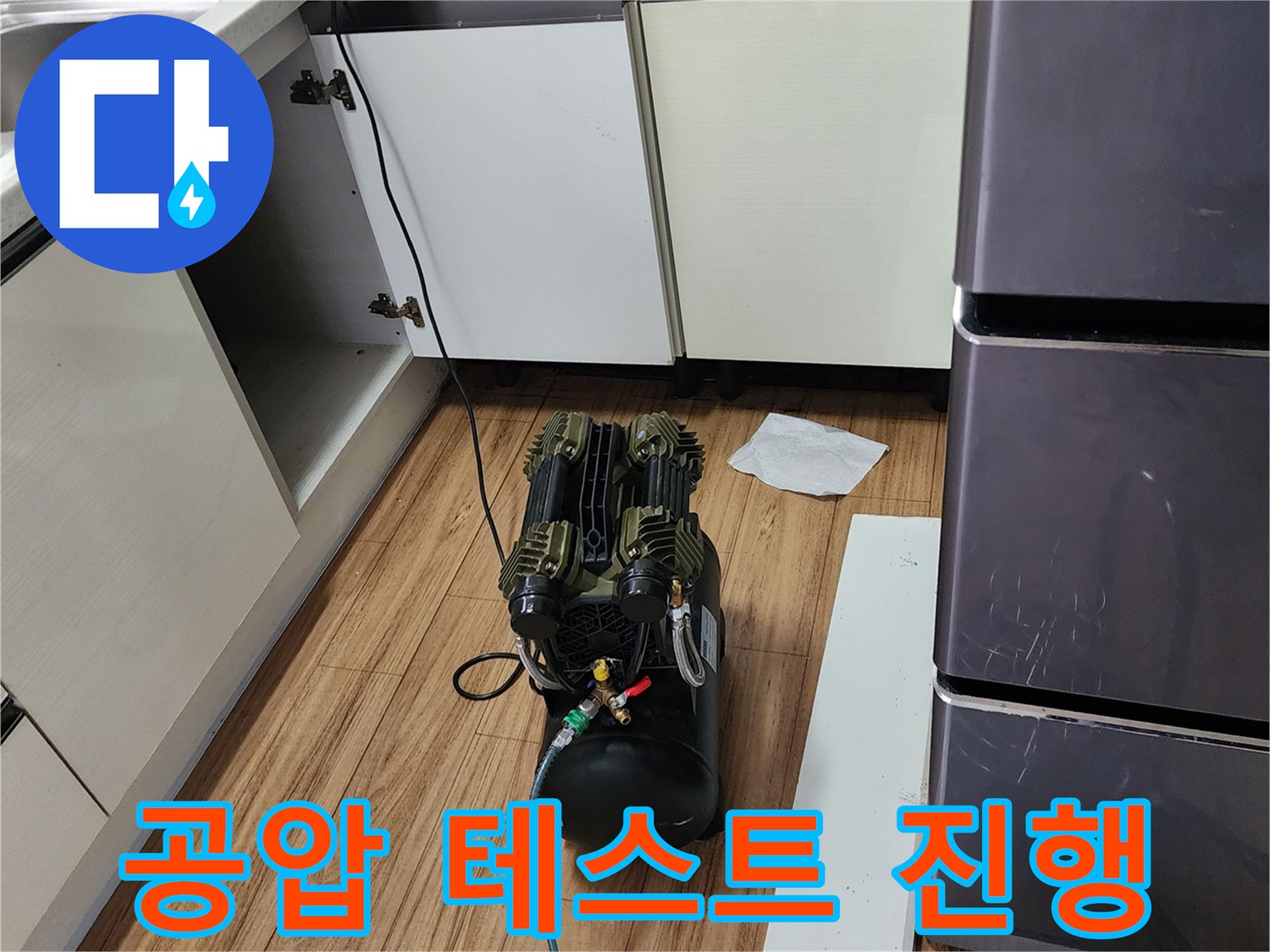 싱크대 하단 배관 연결 부위에 연결된 공압 테스트 장비의 모습