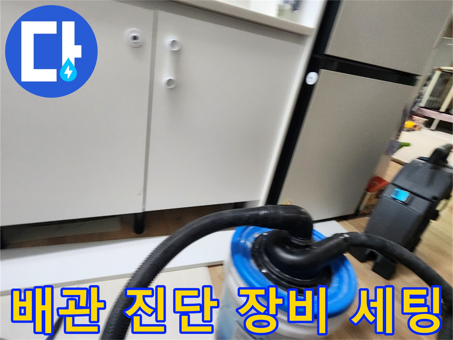 싱크대 밑 바닥에서-진단을 위해 준비된 흡입 호스와 수거 통