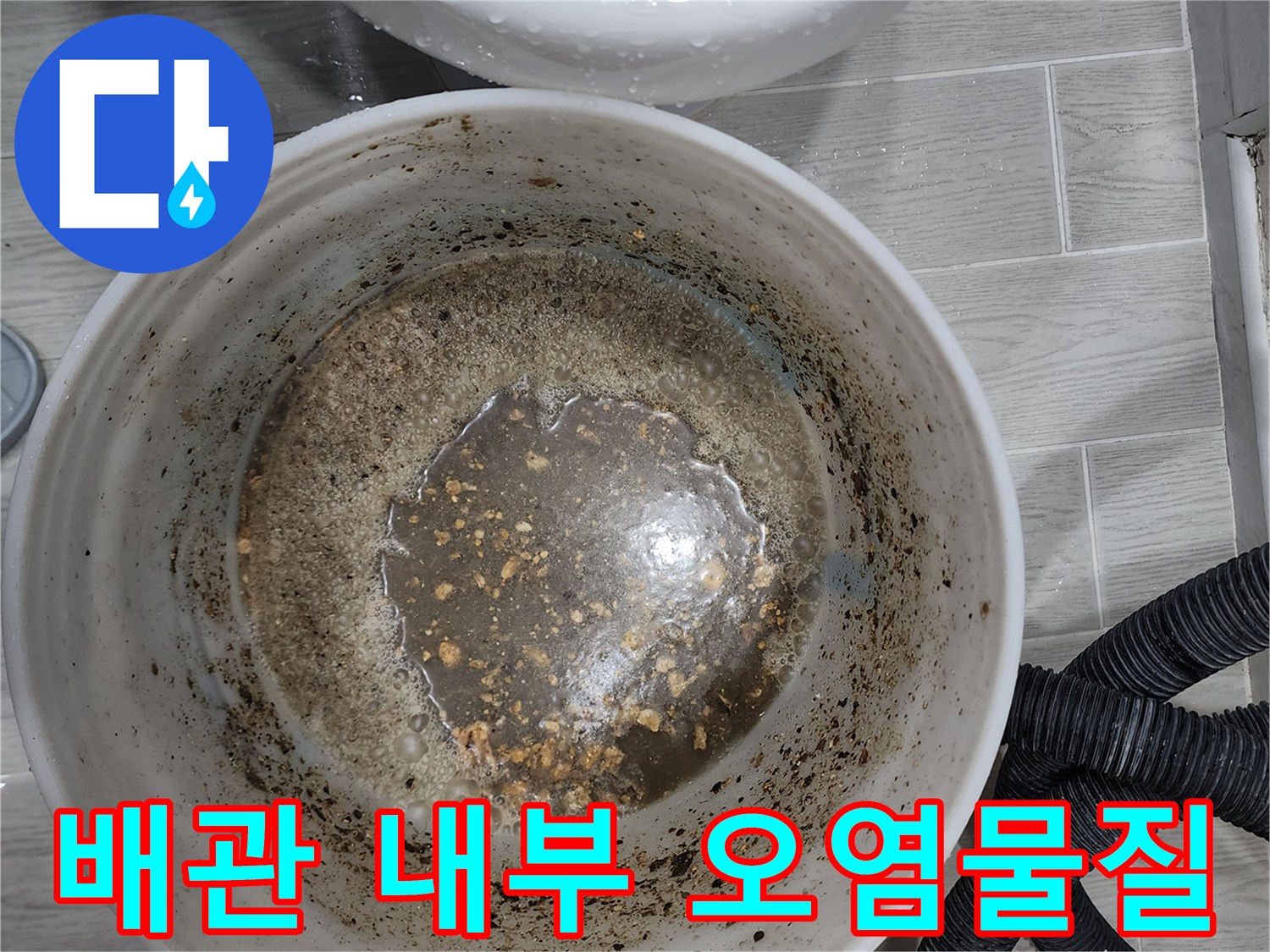 흰색 양동이에 담긴 배관에서 나온 탁한 물과 찌꺼기