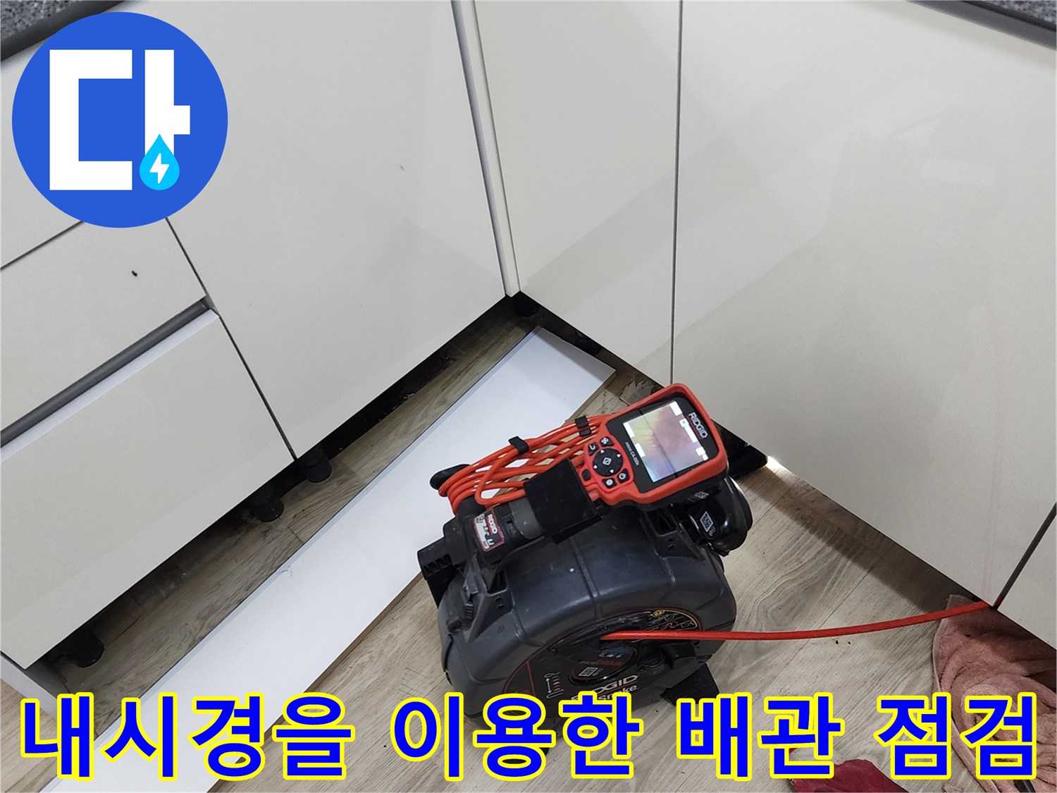싱크대 아래 공간에서 작동 중인 배관 내시경 모니터와 장비