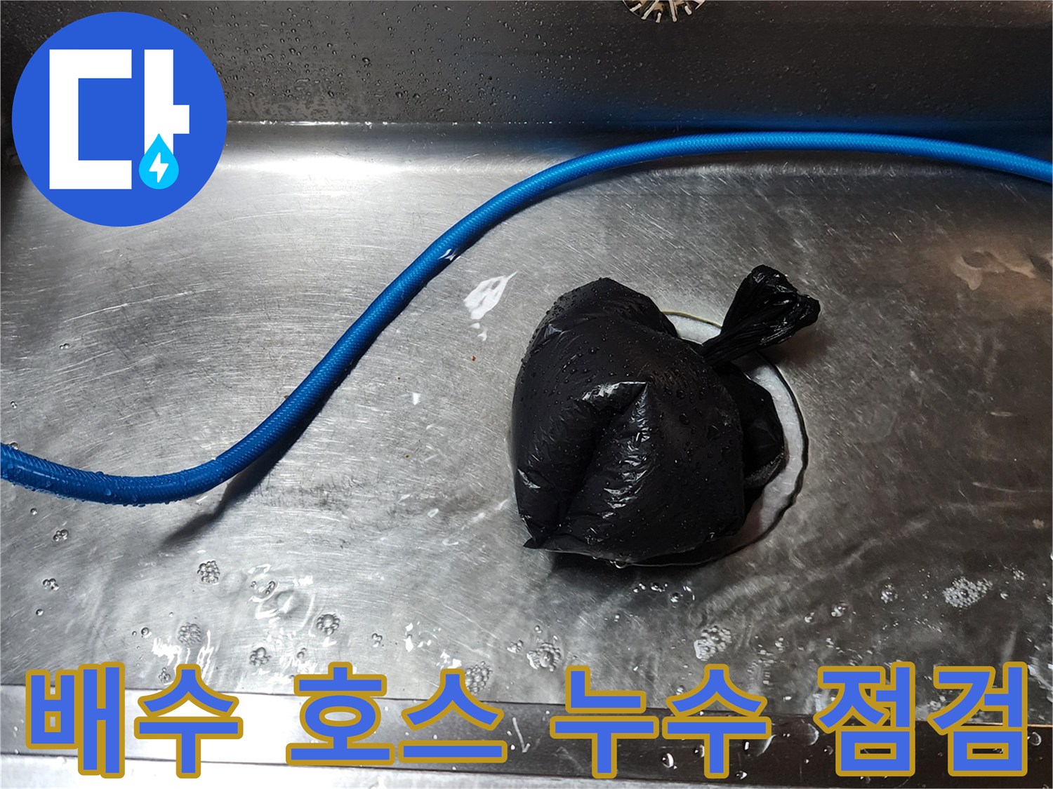 싱크대 배수구 주변의 파란색 호스와 오염된 비닐 뭉치