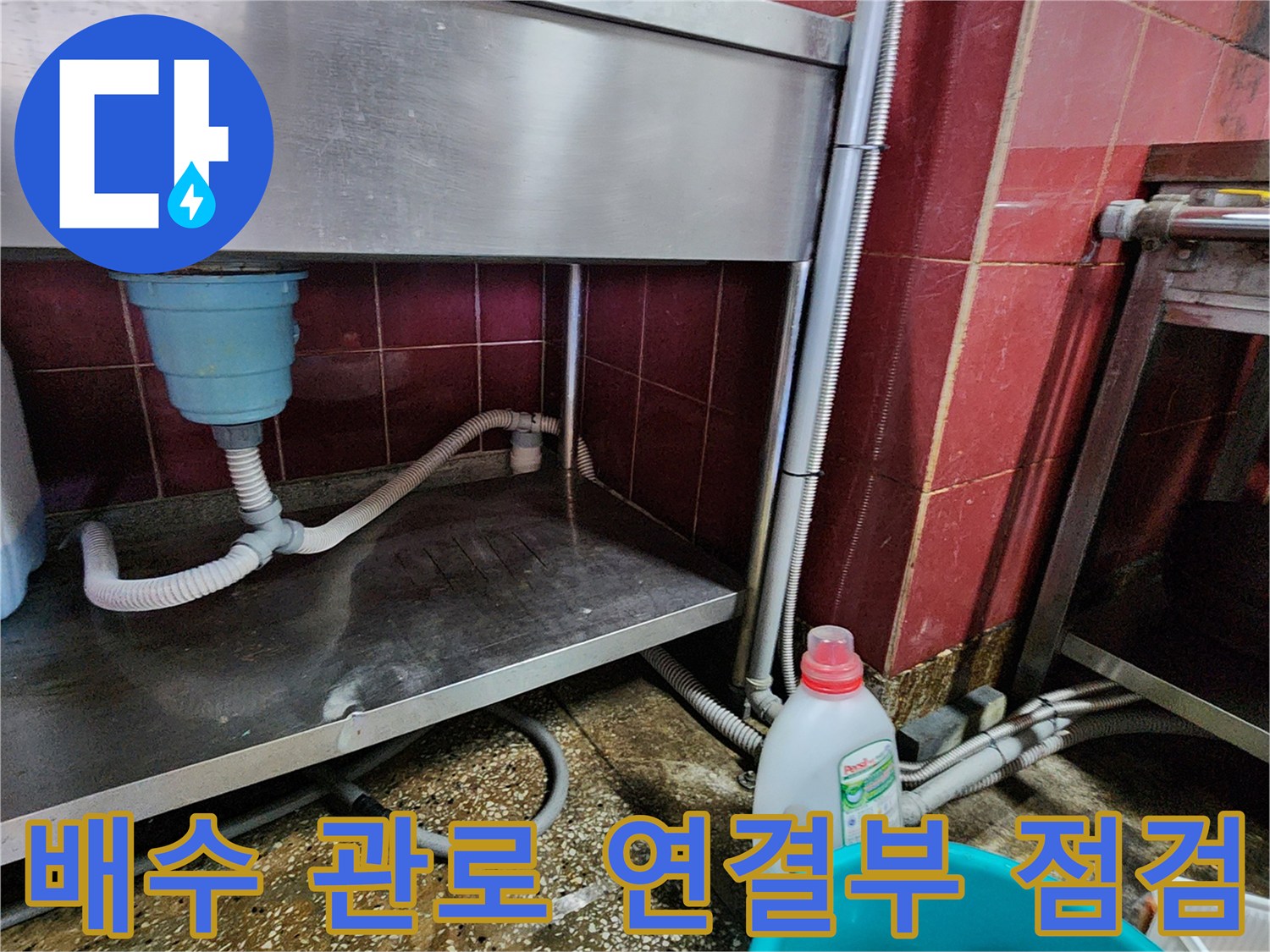싱크대 하단 배수 호스와 벽면 배관의 누수 지점 근접 촬영