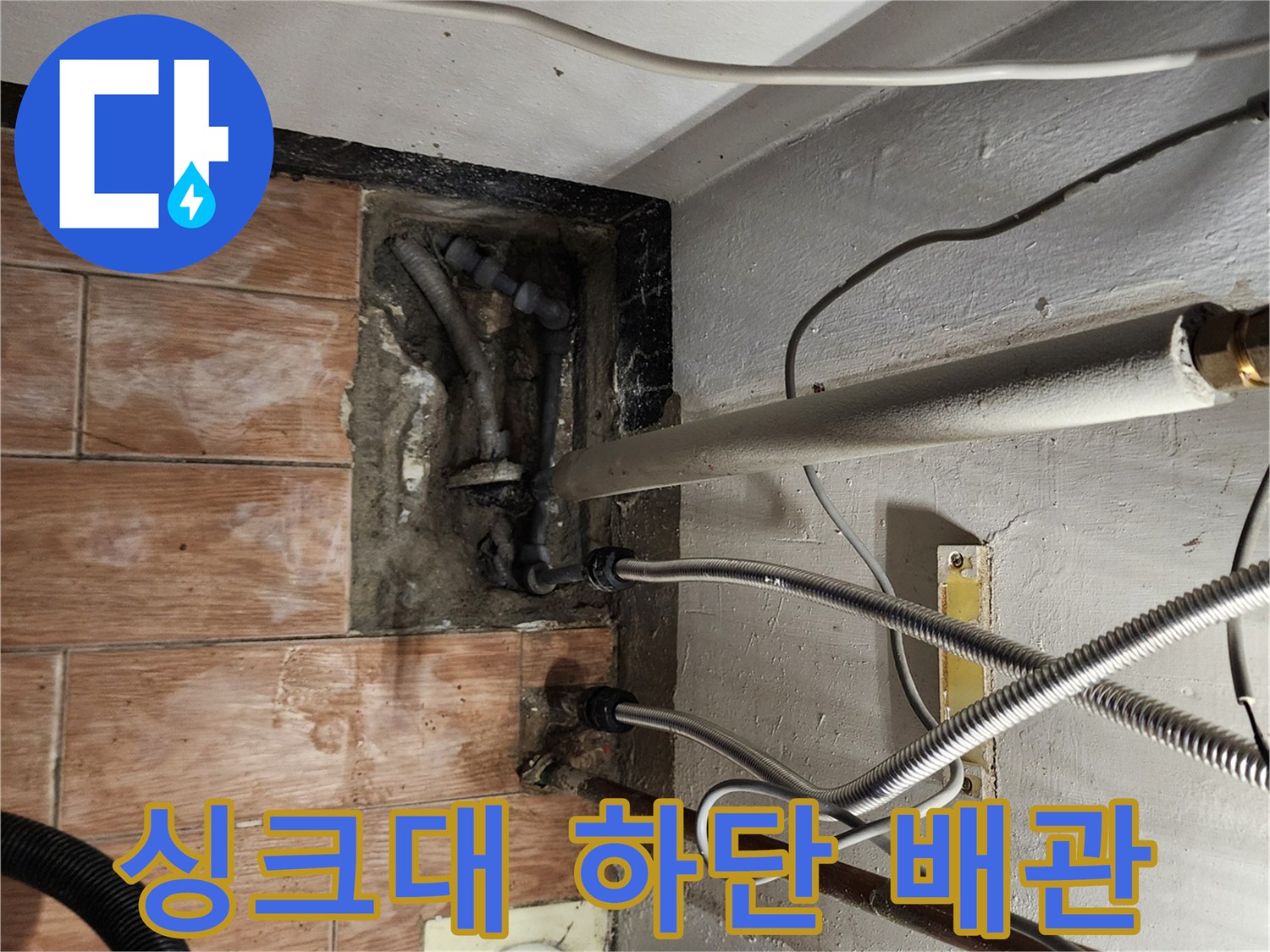 싱크대 아래 바닥에 노출된 배관과 연결 소켓 상태