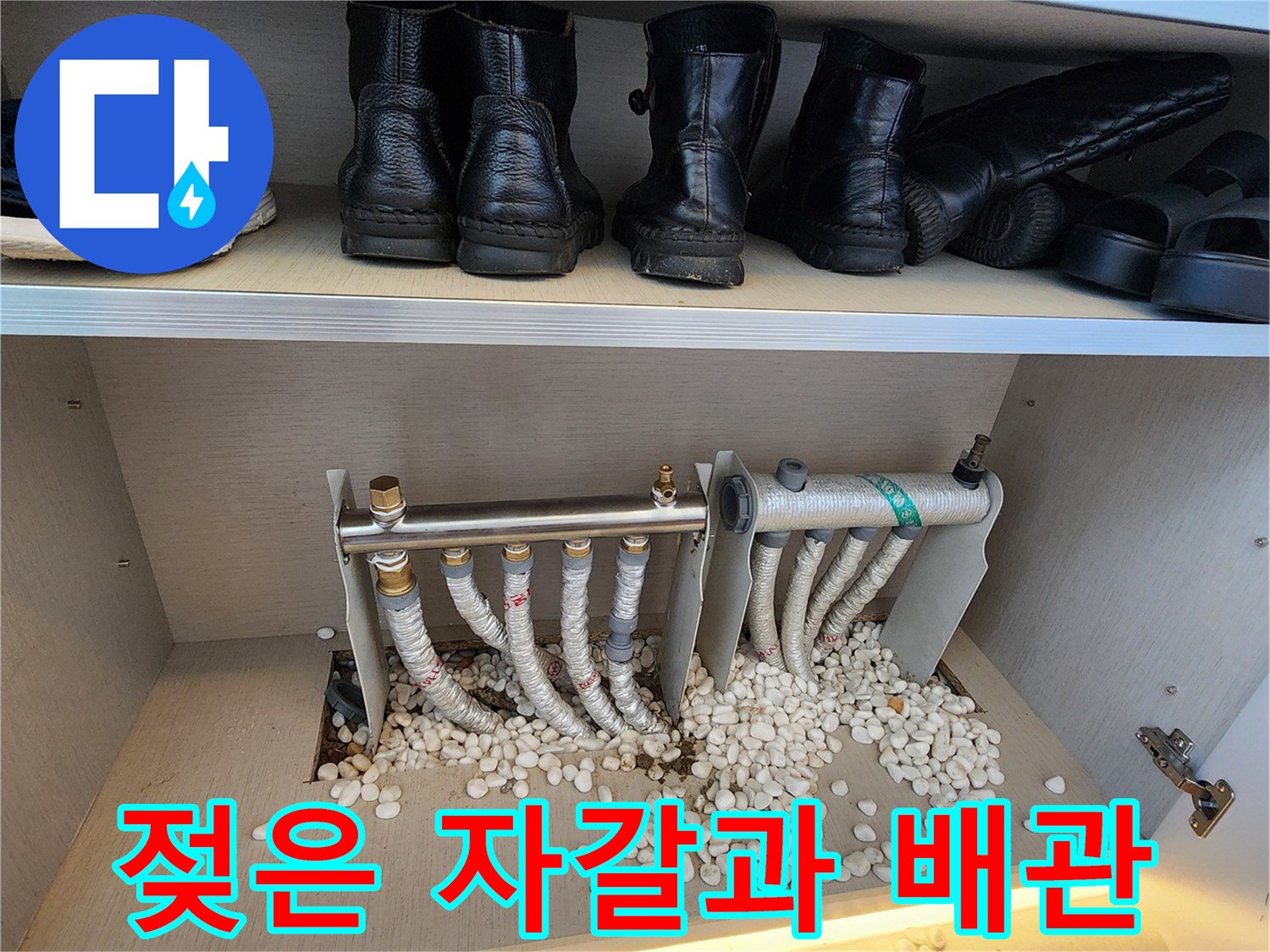 분배기 하단의 젖은 자갈과 보온재 처리된 배관 모습입니다.