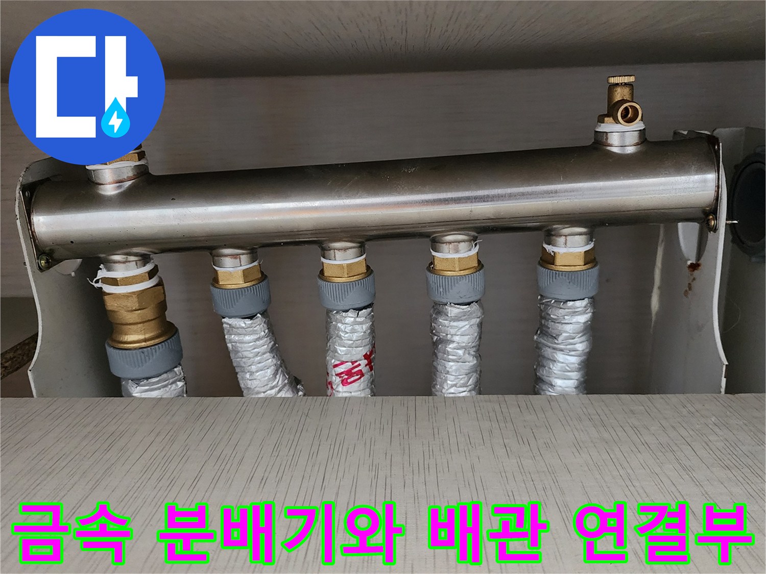 스테인리스 소재의 난방 분배기-보온재로 감싸진 배관 연결 상태
