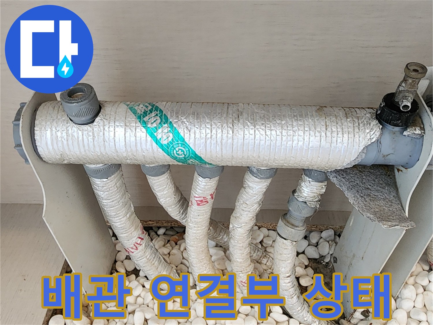 자갈 사이에 위치한-보온재 마감된 배관 부위