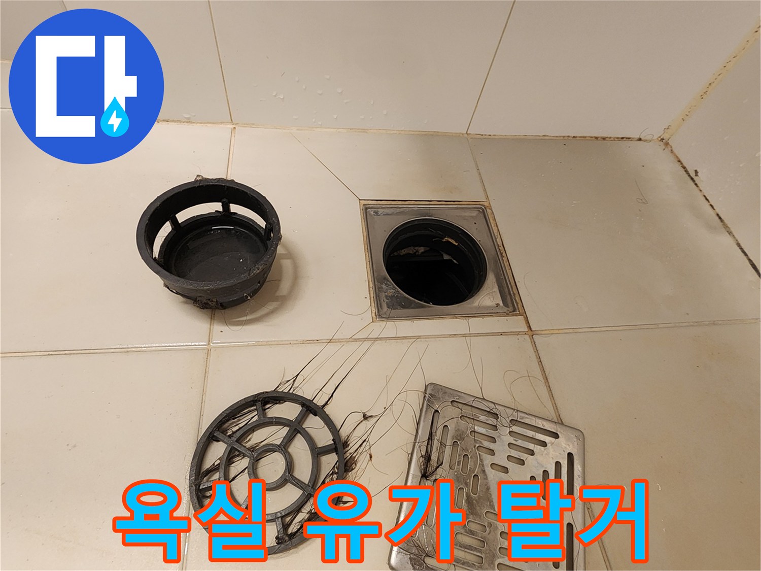분해된 배수구 트랩과 스테인리스 덮개가 타일 위에 놓여 있습니다.