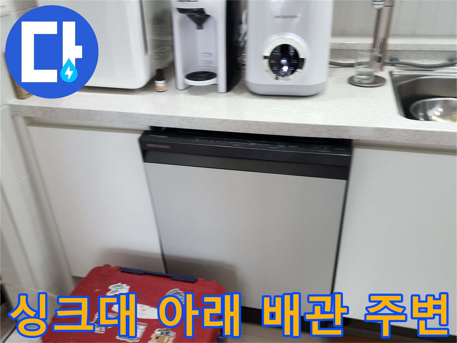 주방 싱크대 하부장 내부의 가전제품과 수납 공간 모습