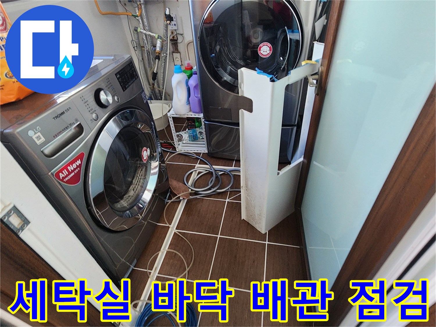 세탁기 뒤쪽 좁은 공간의 배관과 호스 상태를 점검하는 사진