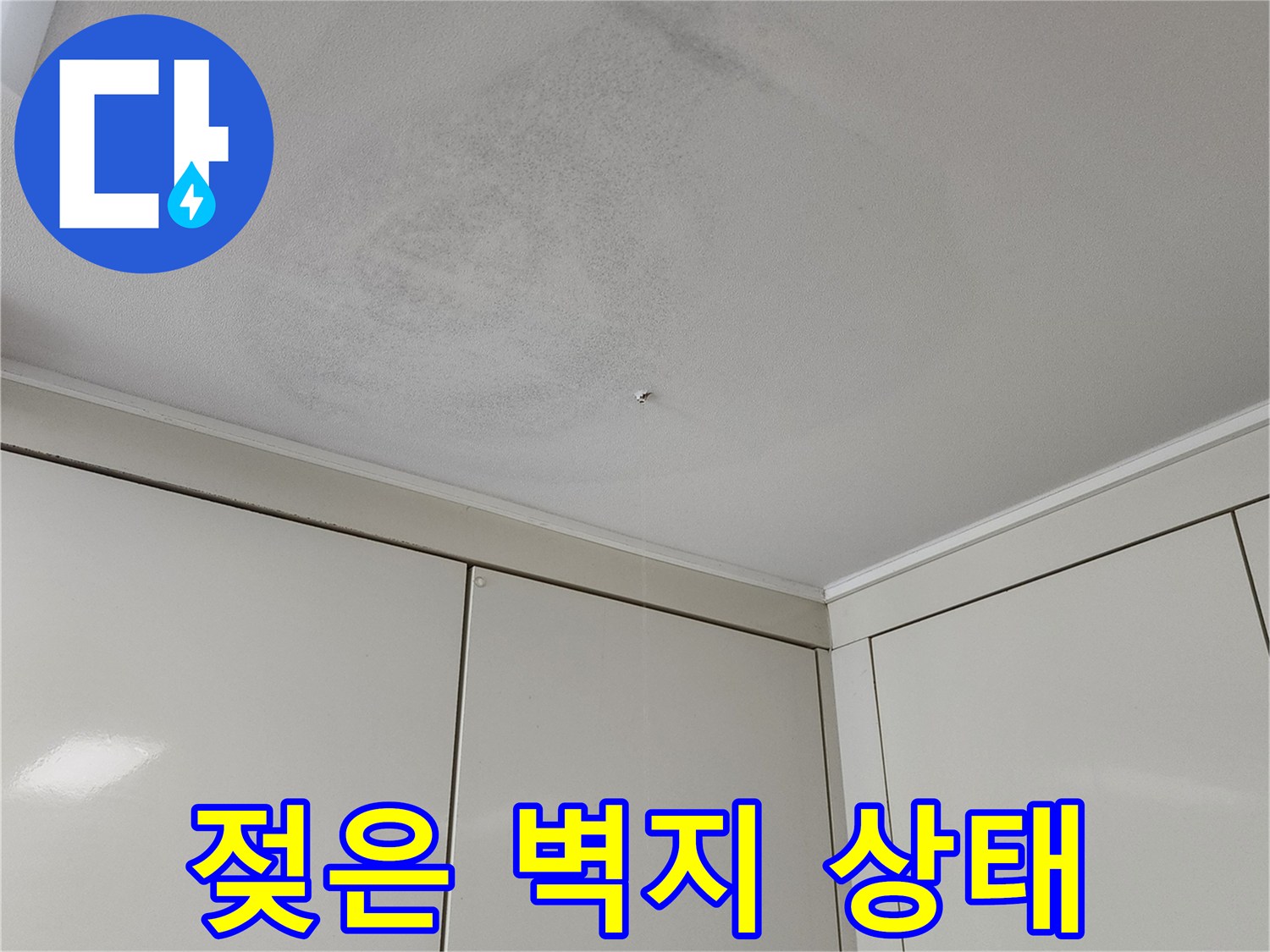 천장과 벽면이 만나는 지점의 오염된 벽지 사진입니다.