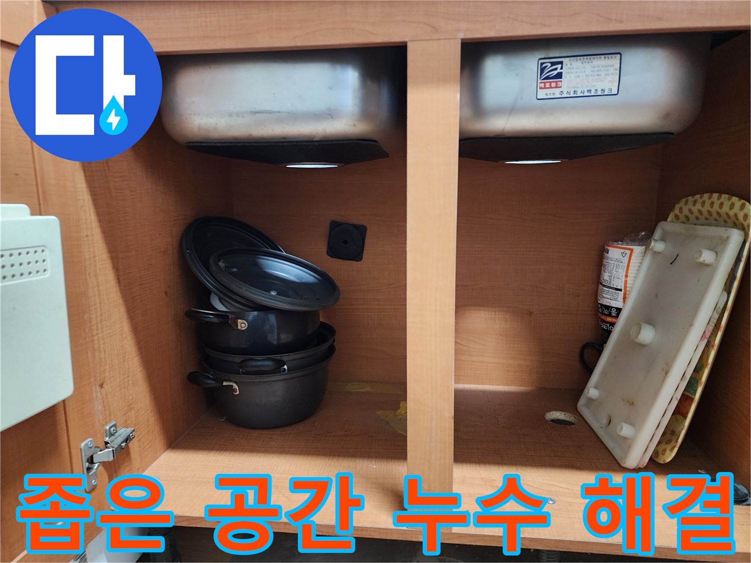 싱크대 하부장 내부 - 누수 부위를 찾기 위해 꼼꼼하게 살펴보고 있습니다.