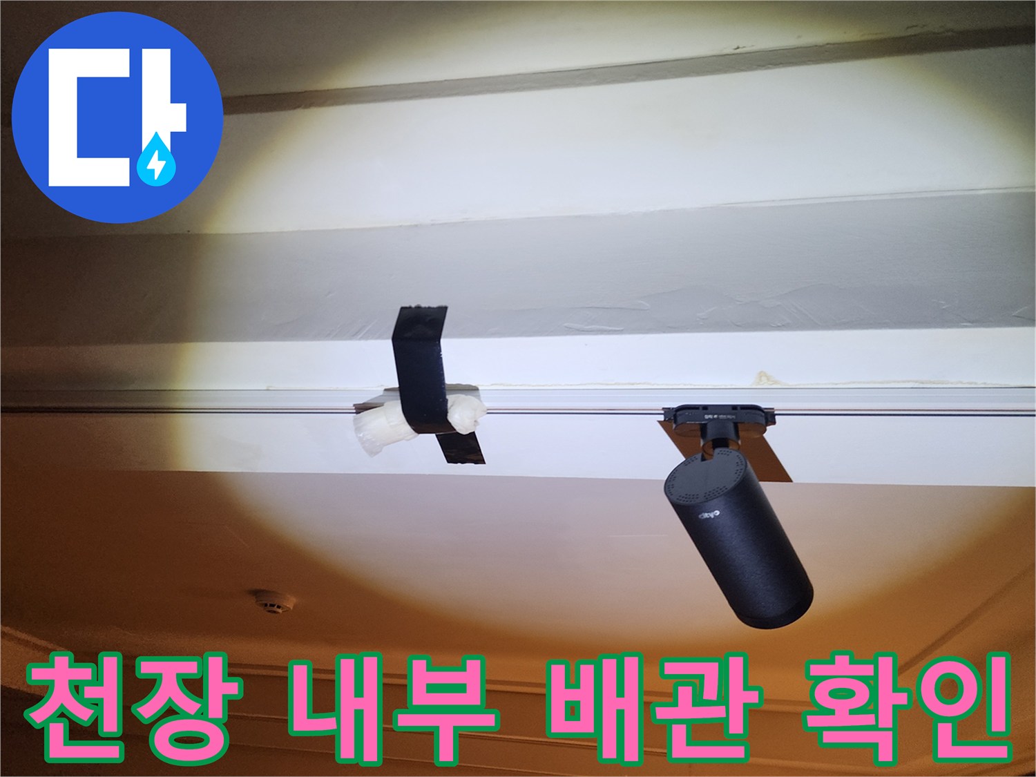 천장 구조물 사이의 검은색 관로를 촬영한 사진입니다