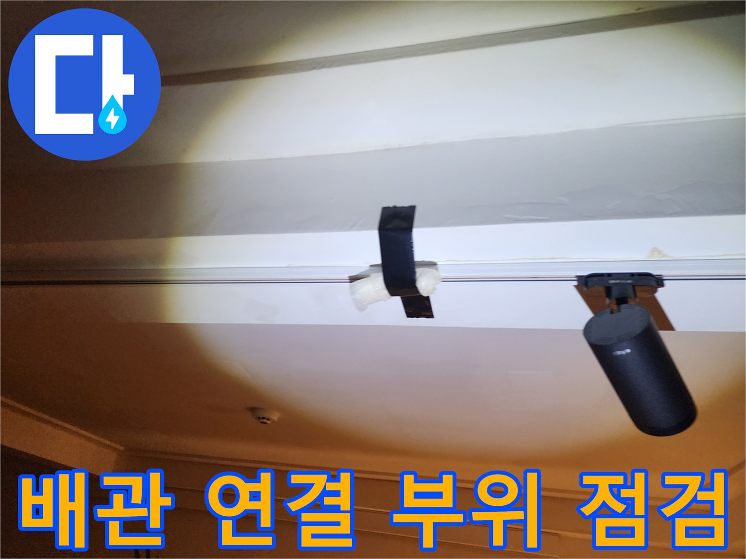 천장에 설치된 검은색 배관 고정 부품과 관로