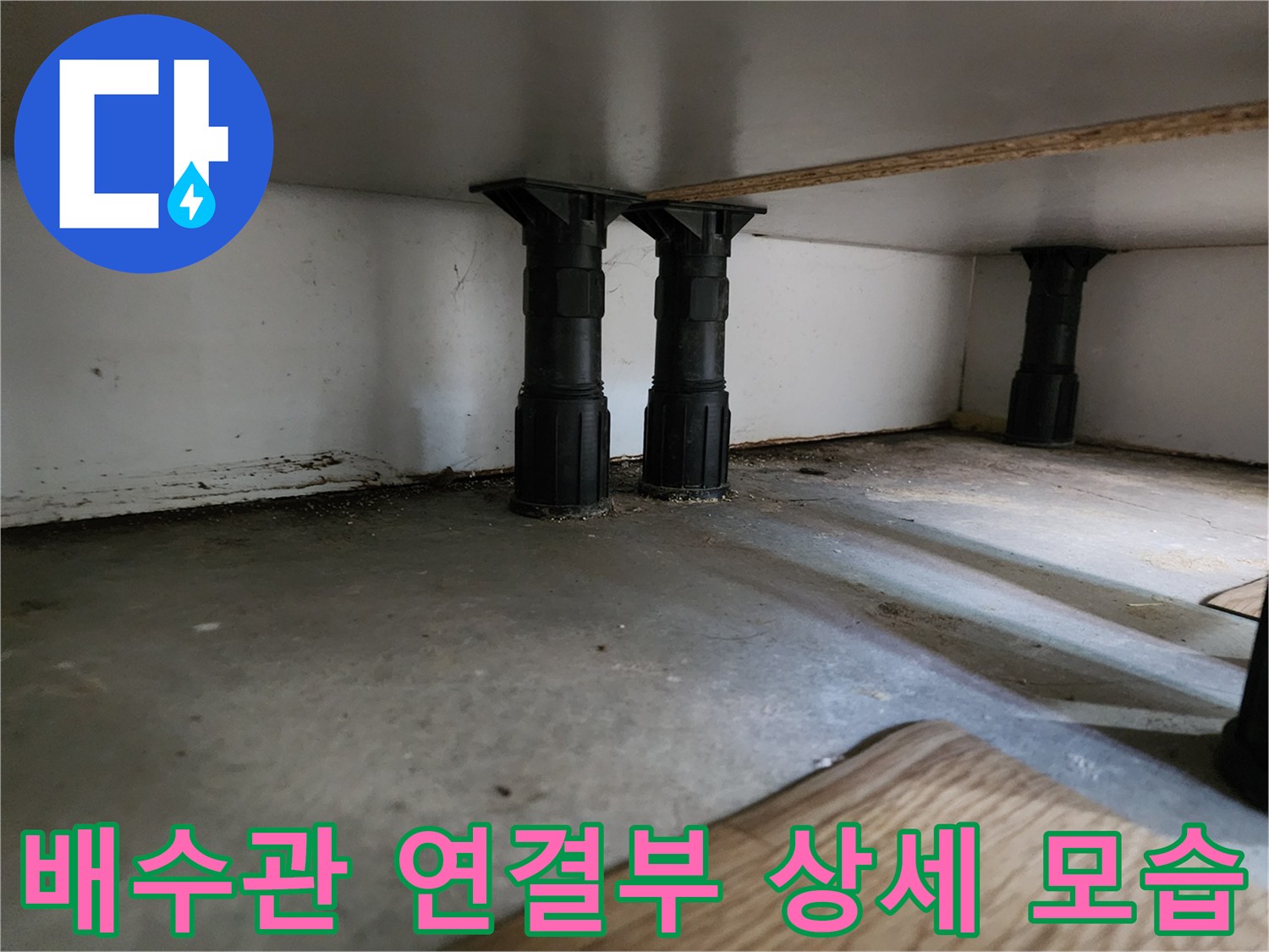 싱크대 밑 바닥에 위치한 검은색 수직 배관들의 배열과 주변 환경 사진