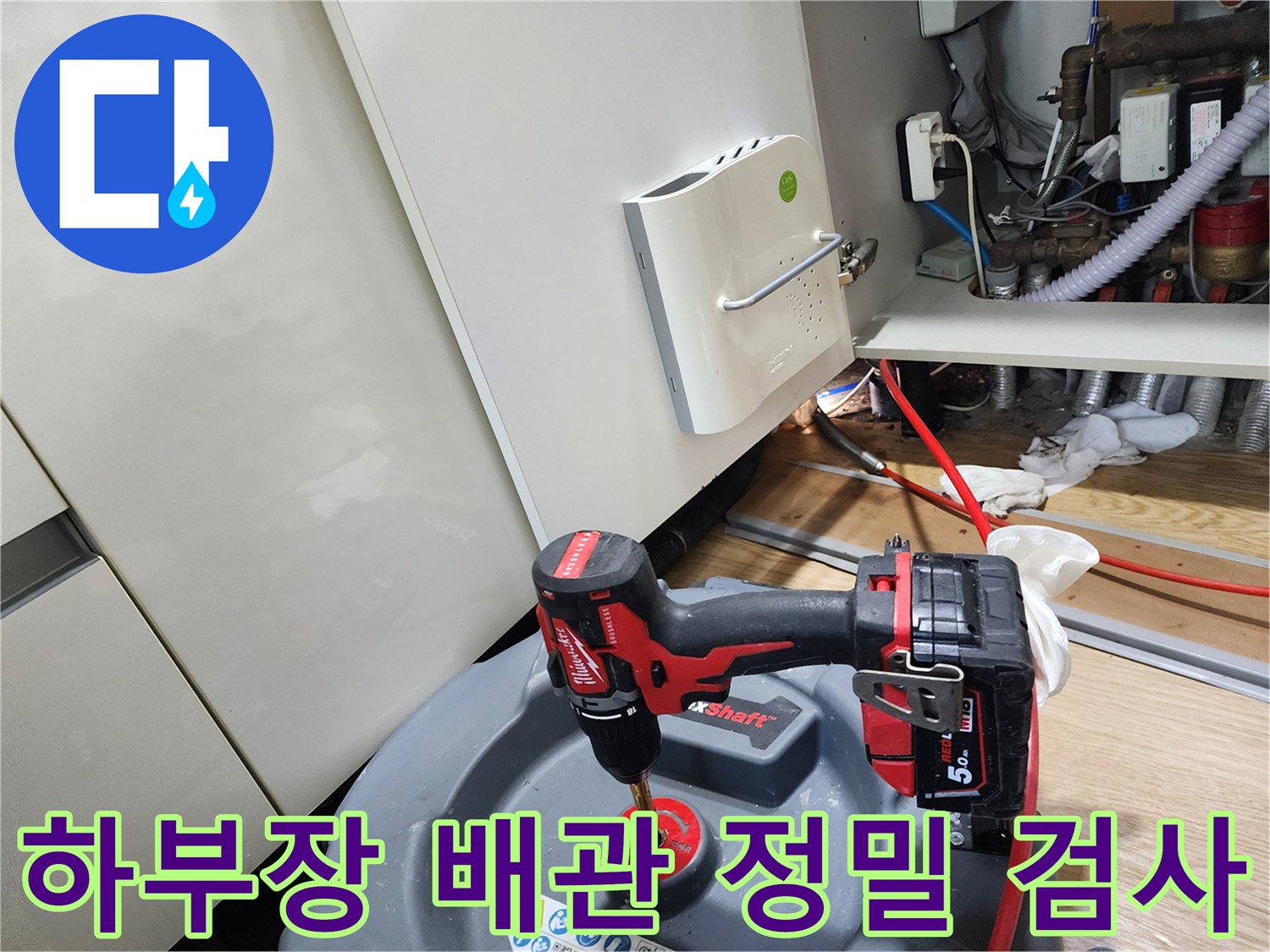 싱크대 아래쪽의 복잡한 배관을 꼼꼼하게 점검하고 있는 모습입니다.