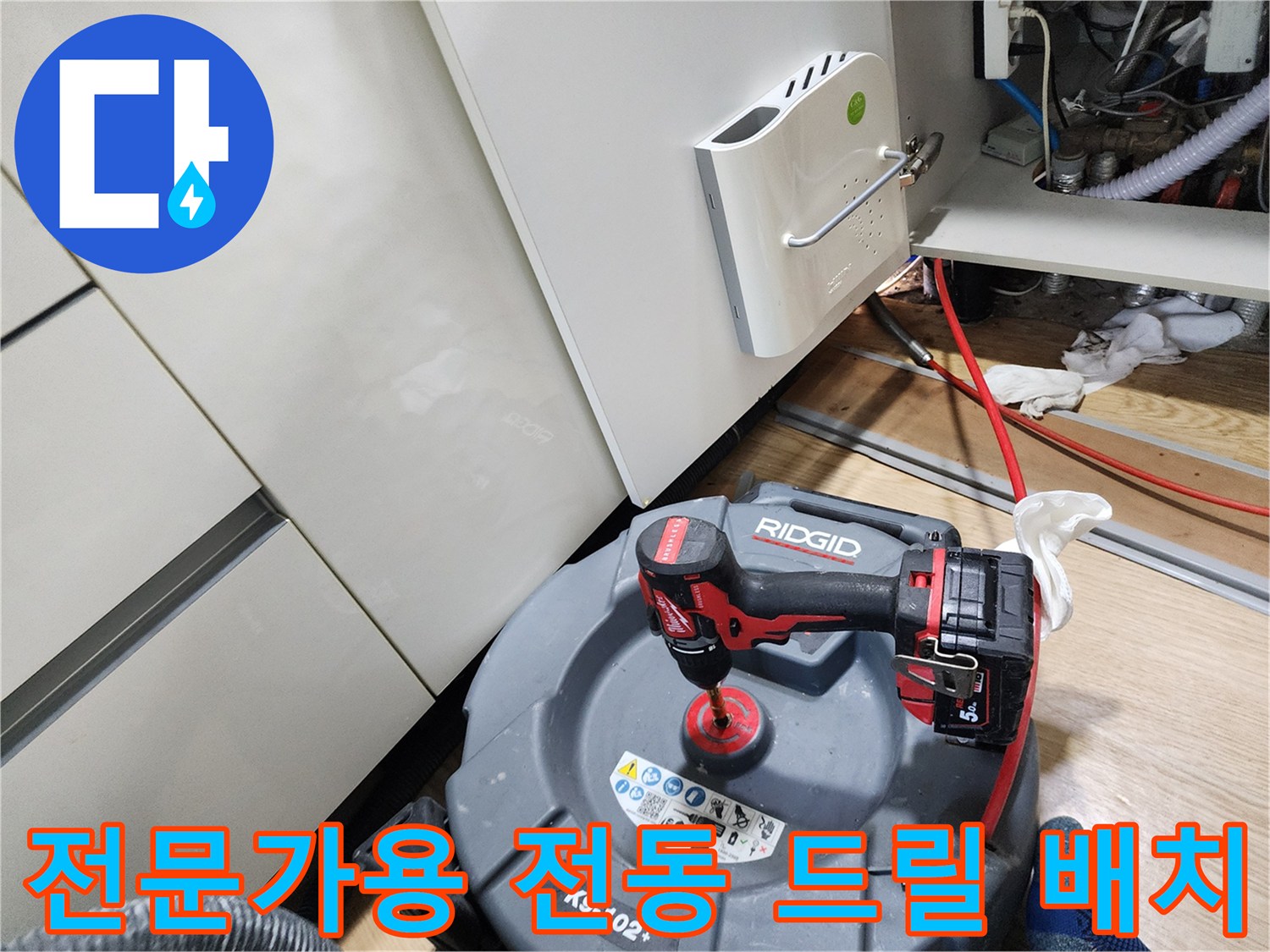 작업을 위해 싱크대 하부에 놓인 RIDGID 브랜드의 공구 세트