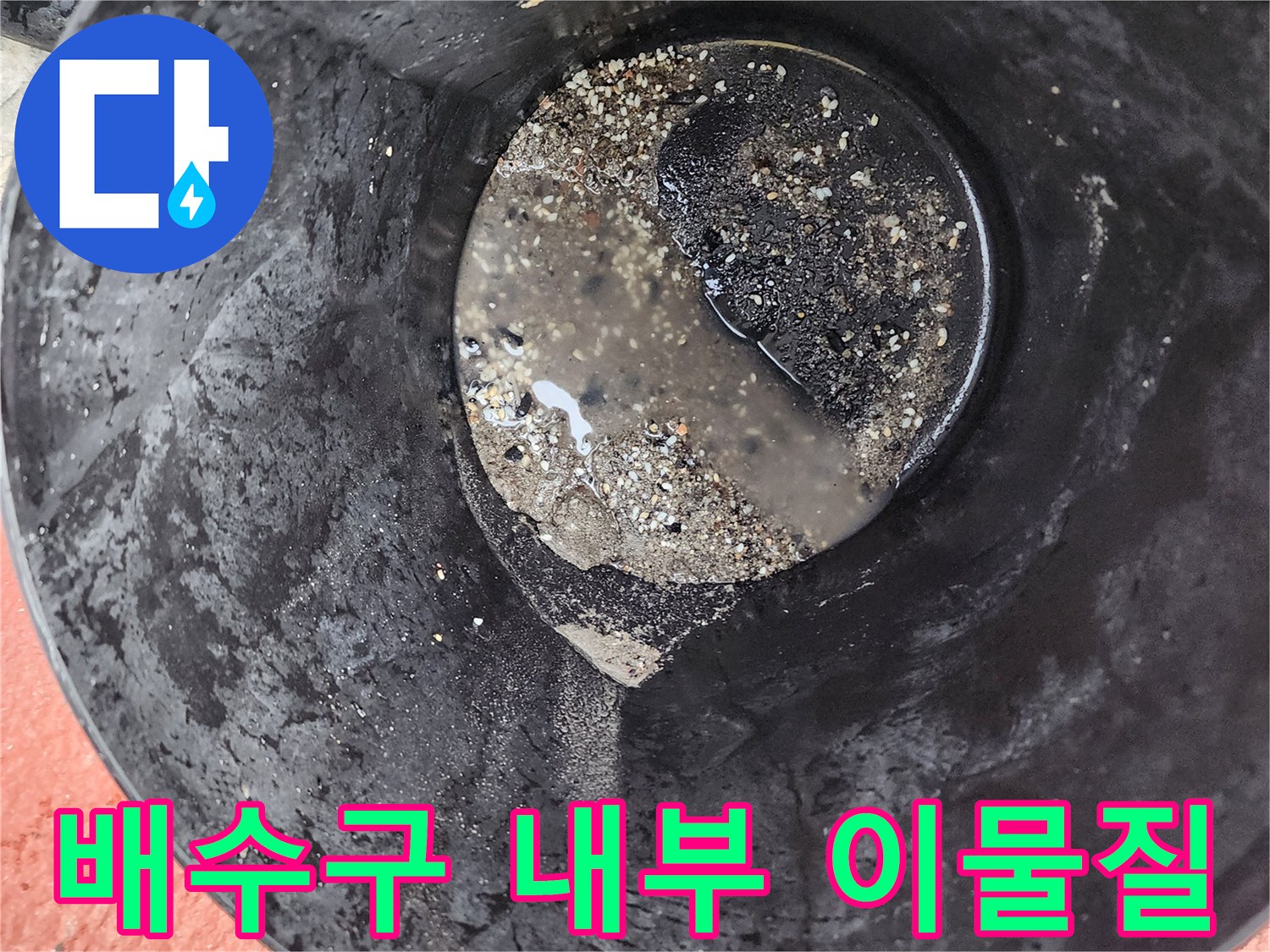 검은색 슬러지가 고여 있는 배수 용기