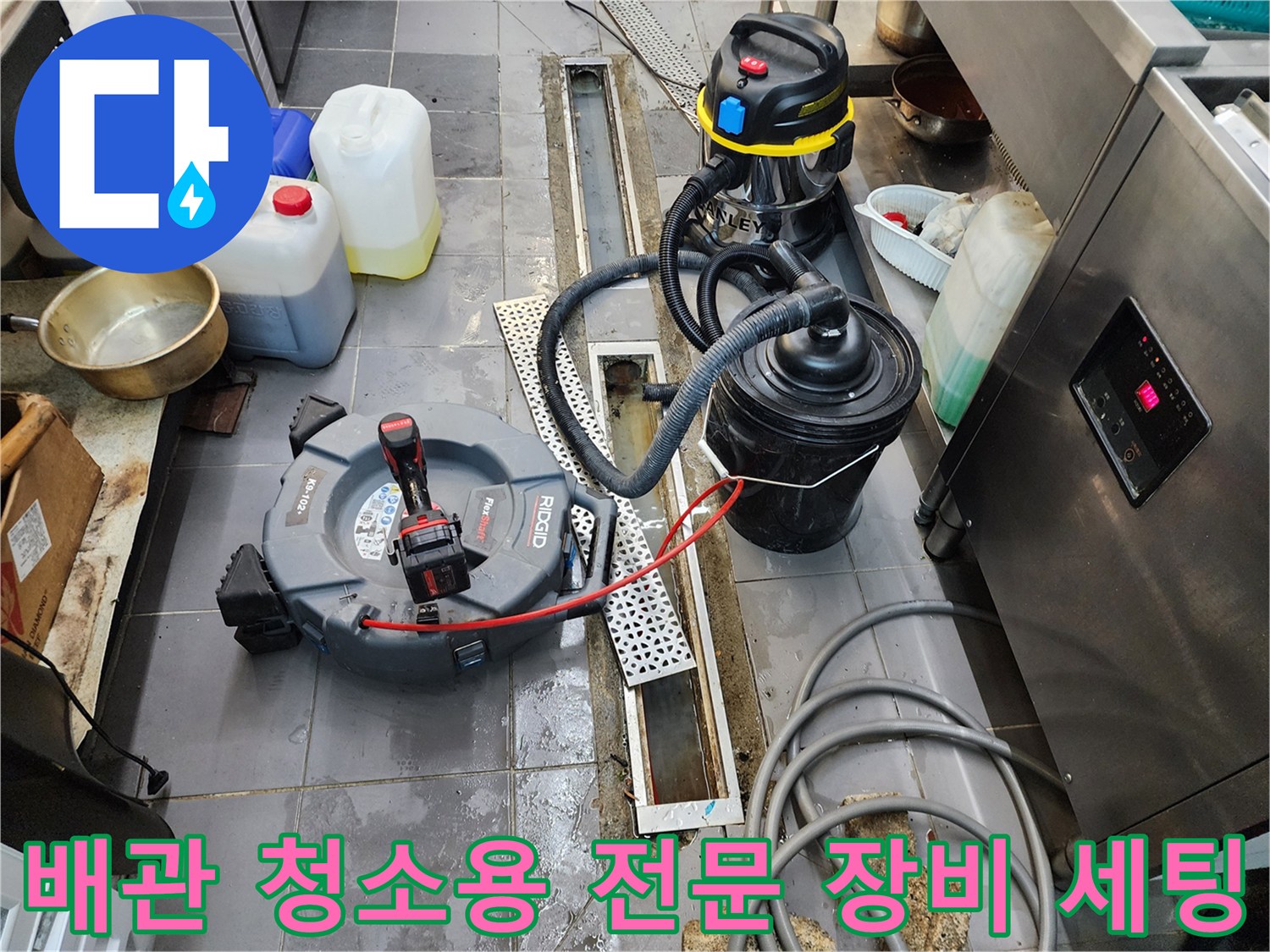 배관 속 이물질 흡입을 위해 배치된 산업용 습식 청소기와 배관 장비