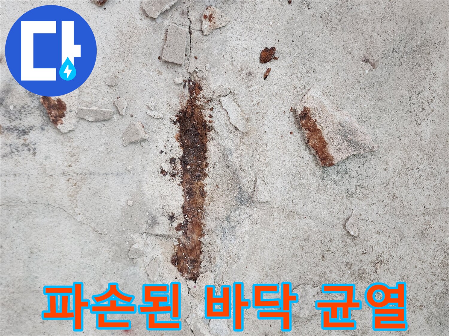 붉은 녹물이 섞인 콘크리트 파편과 갈라진 슬래브 면