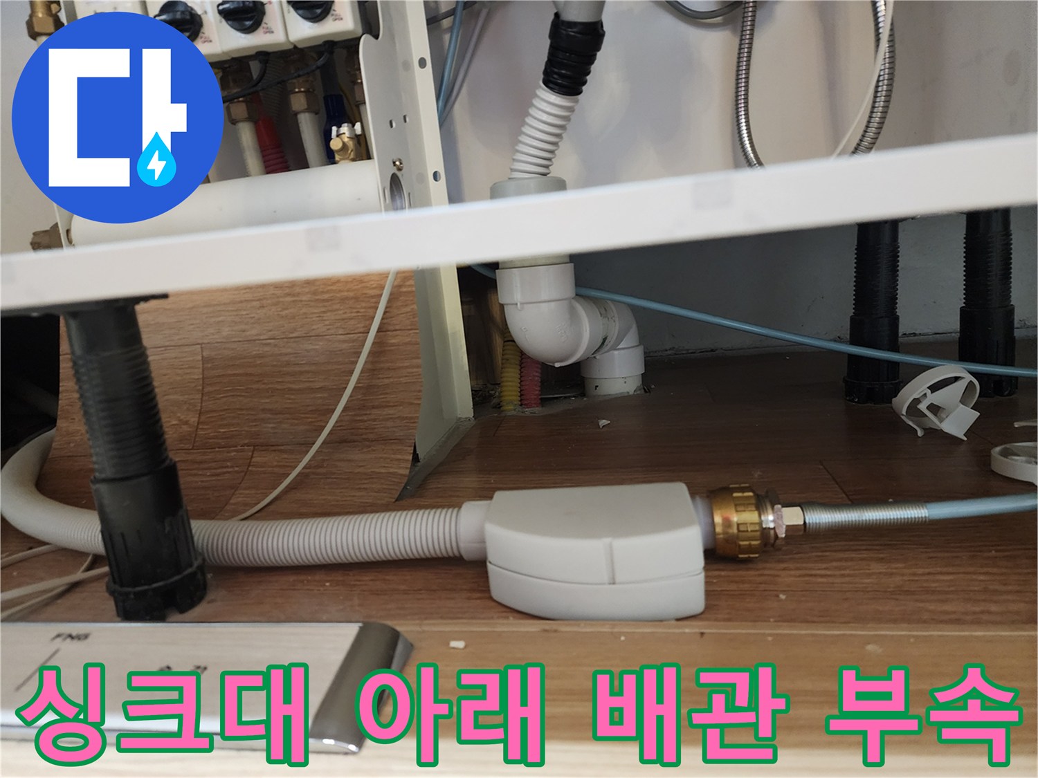 복잡하게 얽힌 주방 하부장 배관과 연결 호스들
