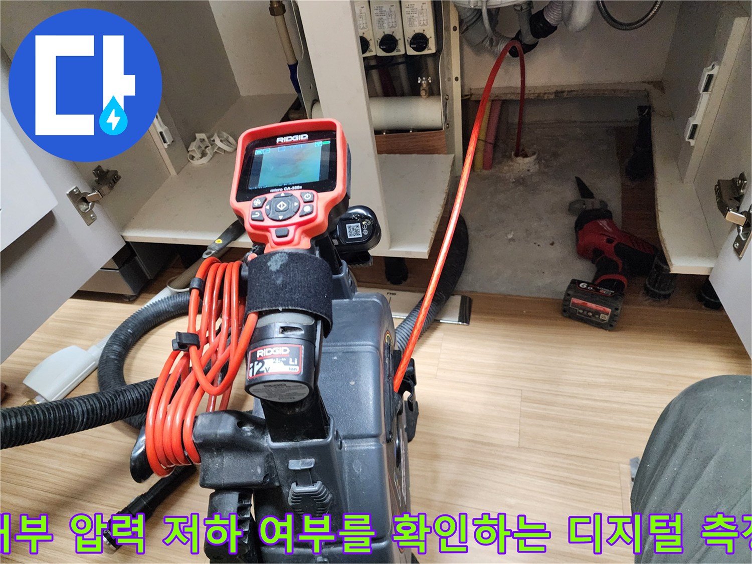 싱크대 하부장 안쪽에서 진행 중인 수도 배관 공압 테스트 과정입니다.