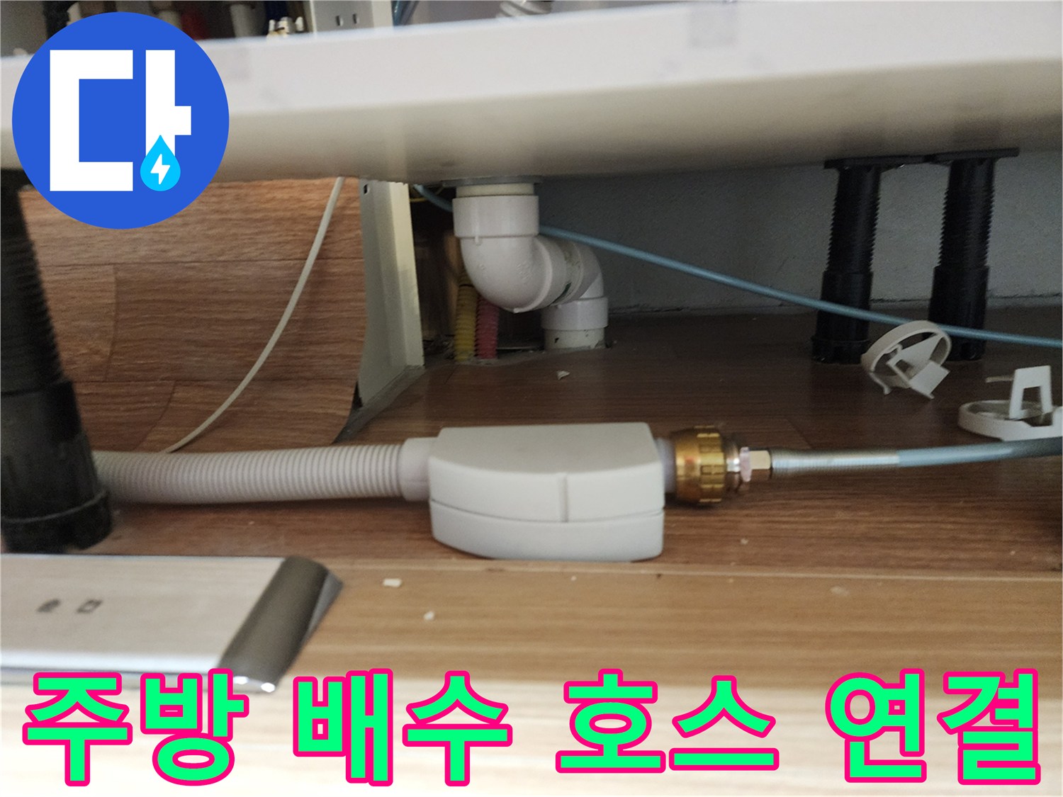 하얀색 주름관과 금속 부속이 연결된 배수 시스템 구조