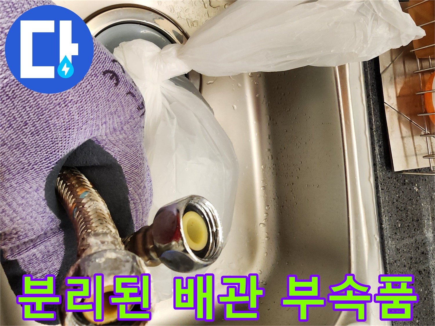 싱크대에서 분리하여 상태를 확인 중인 온수기 연결 호스