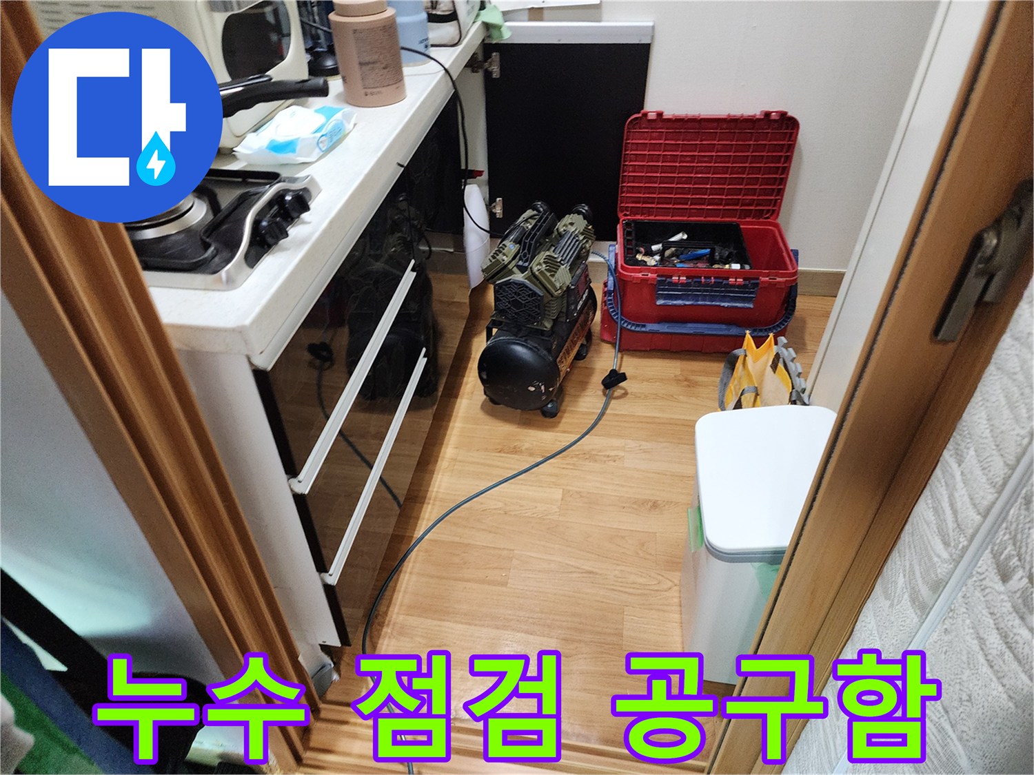 싱크대 밑 작업 공간에 놓인 전문 수리 도구와 장비들