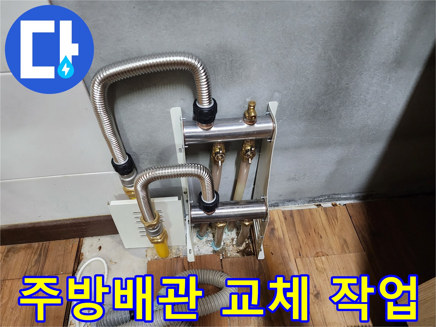 싱크대 하부장 아래 스테인리스 주름관과 분배기 부속을 새로 설치한 모습입니다.