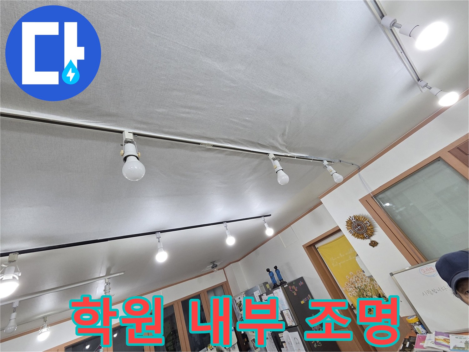 천장에 설치된 레일 조명과 하얀색 천장 마감재-누수 지점 탐색 중