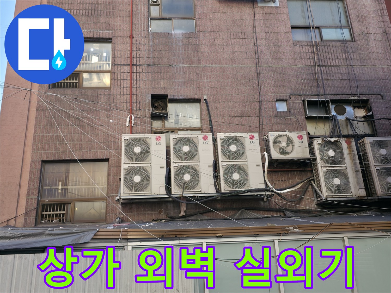 상가 건물 외벽에 설치된 여러 대의 에어컨 실외기와 배관 상태
