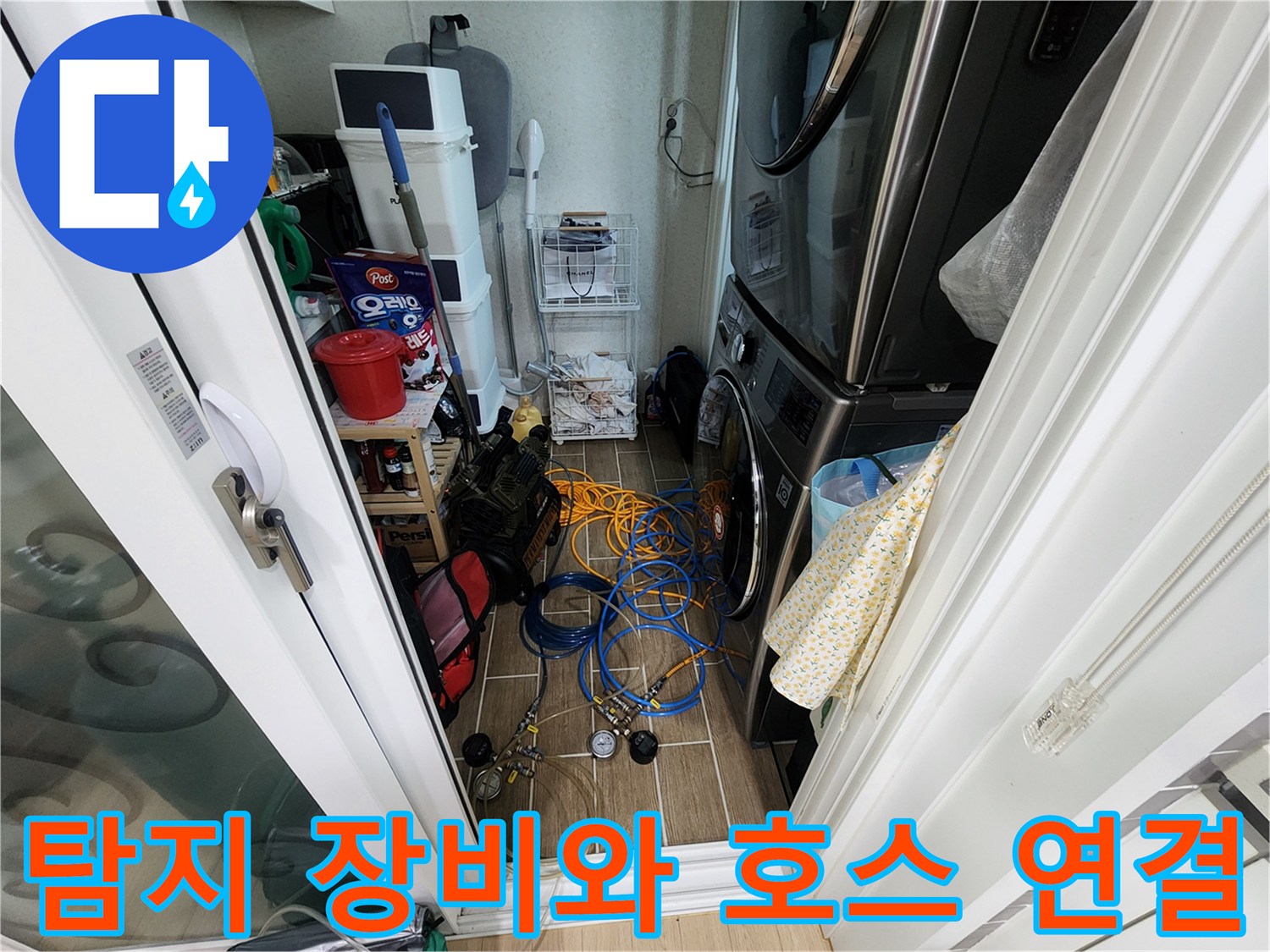 바닥에 놓인 파란색 배관용 가스 호스와 압력계 부속품