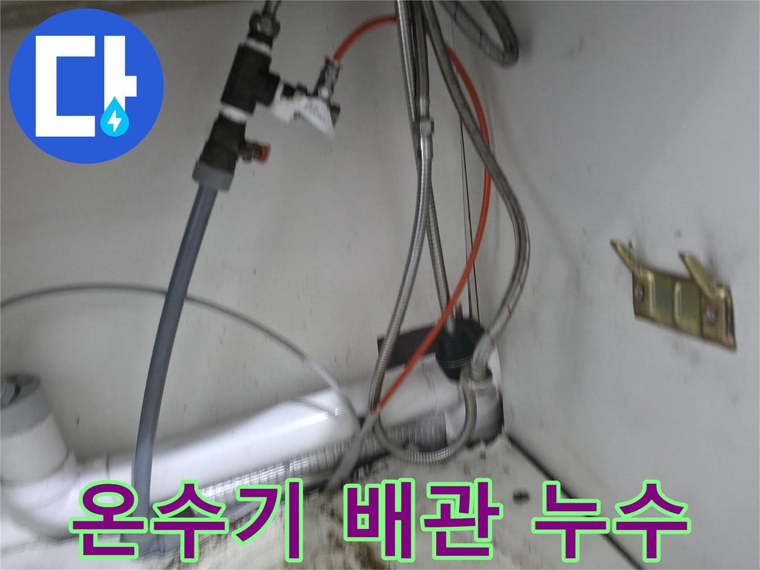 사무실 싱크대 아래 전기 온수기와 연결된 배관의 부식 상태를 보여주는 사진입니다.