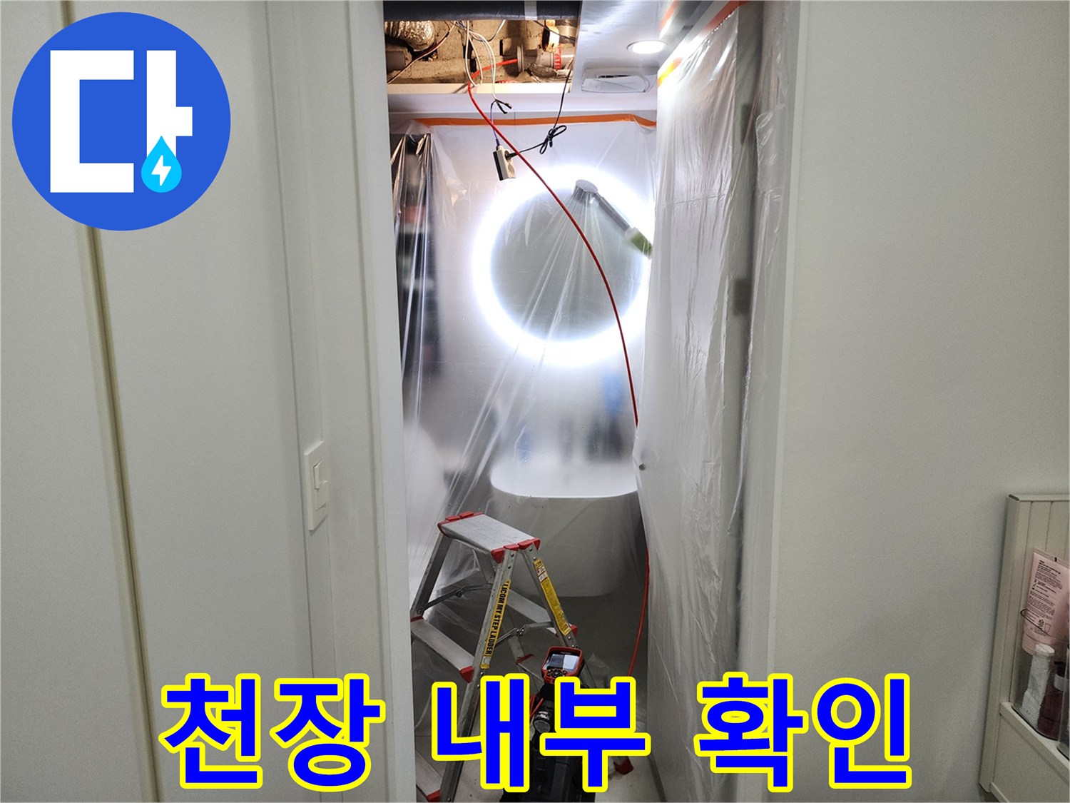 어두운 천장 속-조명을 사용하여 배관의 결함을 찾는 중입니다.