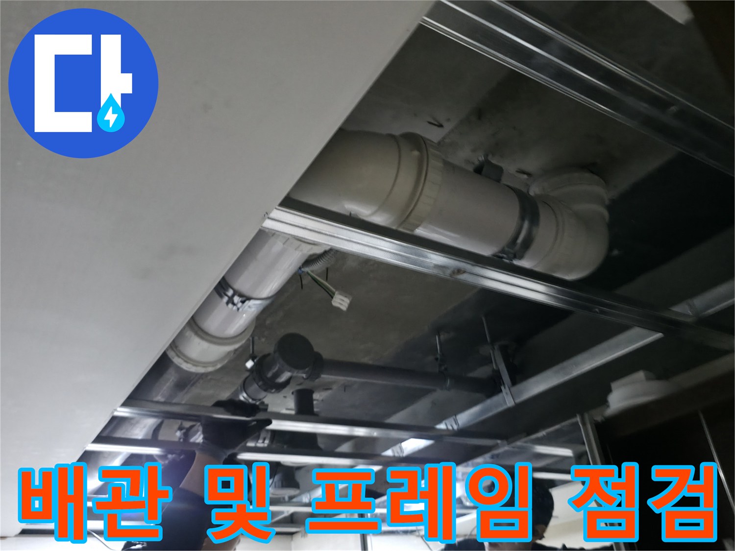 천장 내부의-은색 오수 배관과 금속 지지대 구조 확인