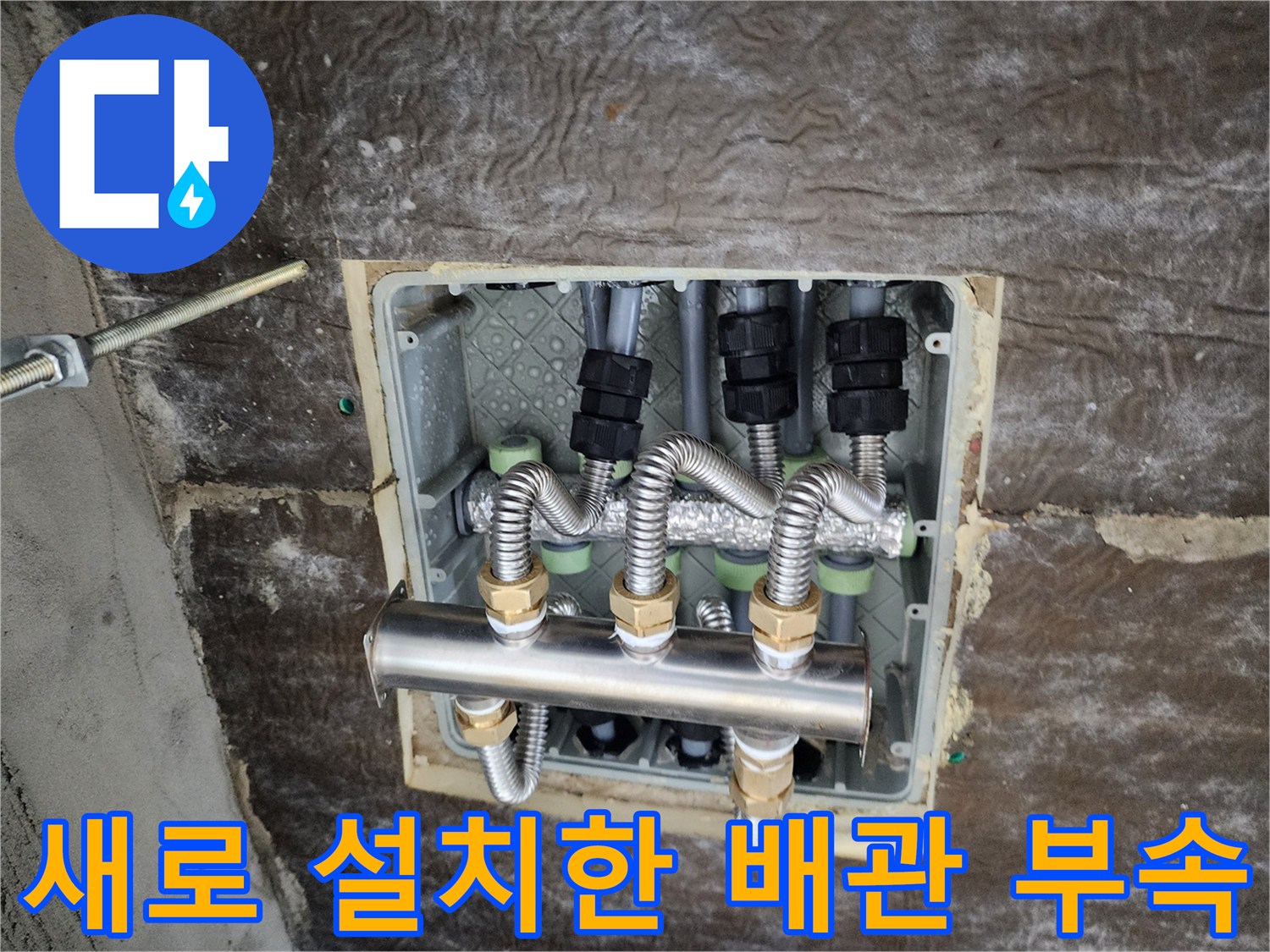 보온재로 마감된 신규 배관 연결 부위와 스테인리스 분배기