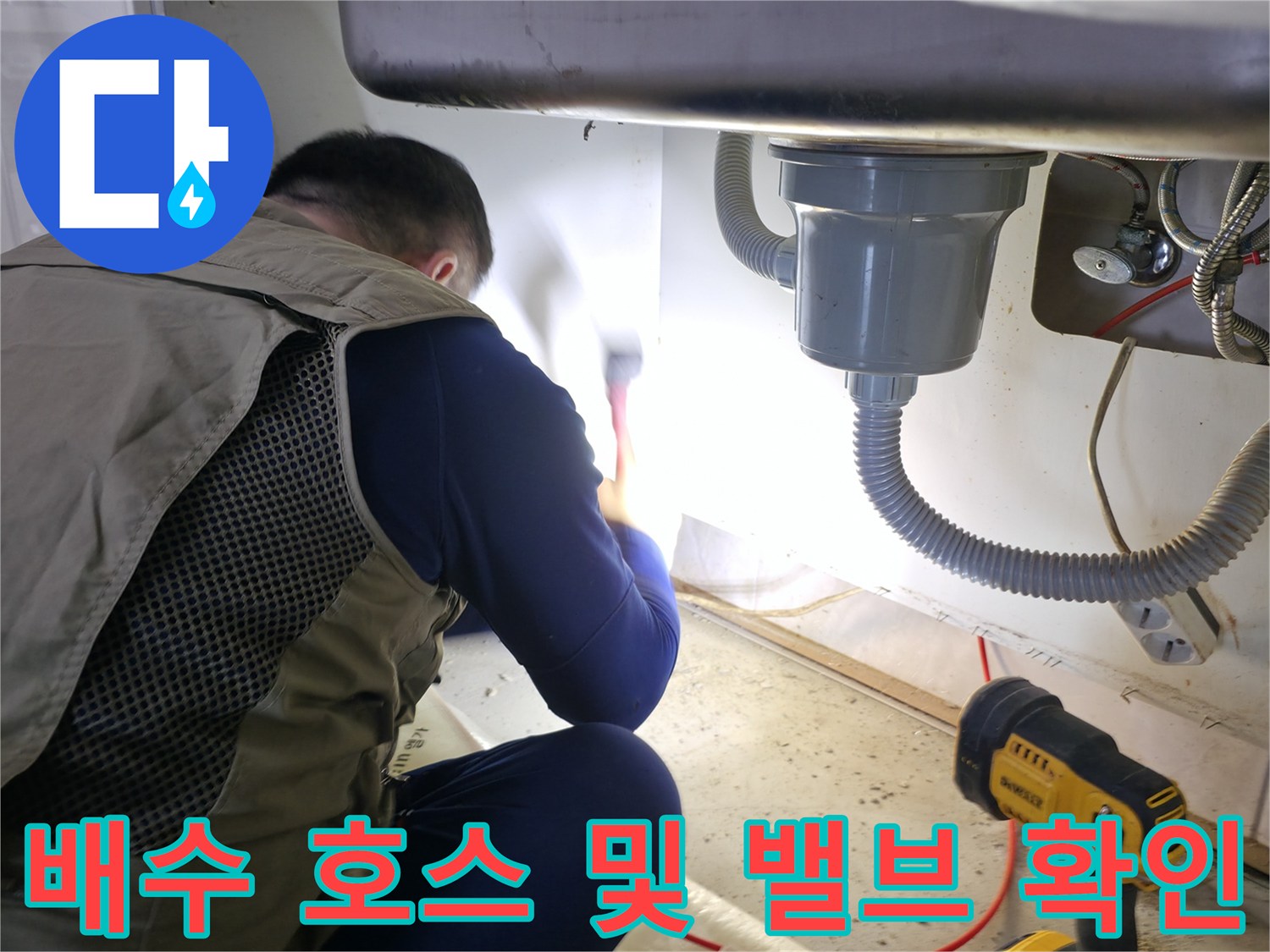 싱크대 배수 호스와 벽면 수도 밸브의 연결 상태를 점검하는 사진