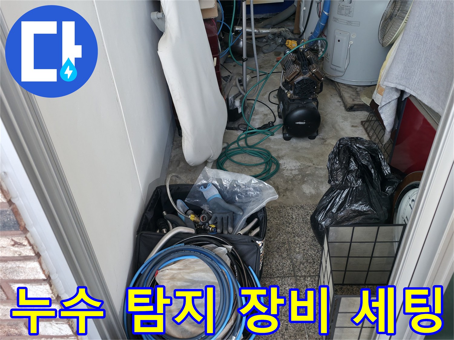 싱크대 아래 좁은 공간에 놓인 누수 측정용 호스와 부품들