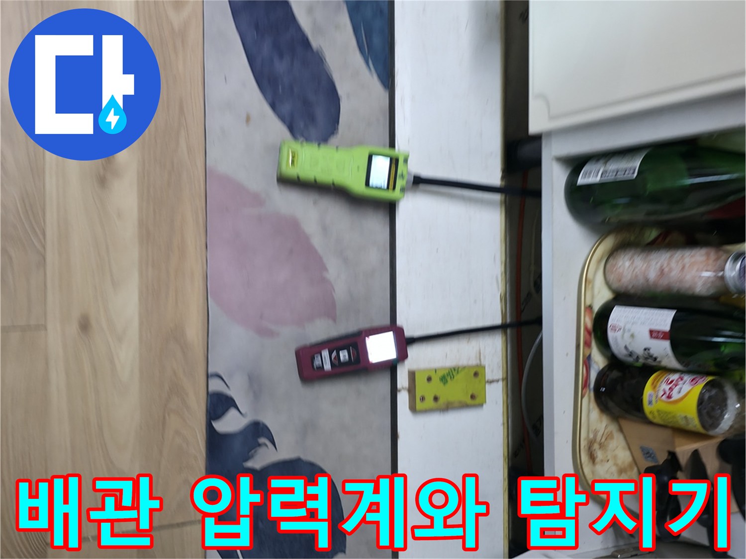 싱크대 하부 배관에 연결된 노란색 압력계와 가스 측정 장비