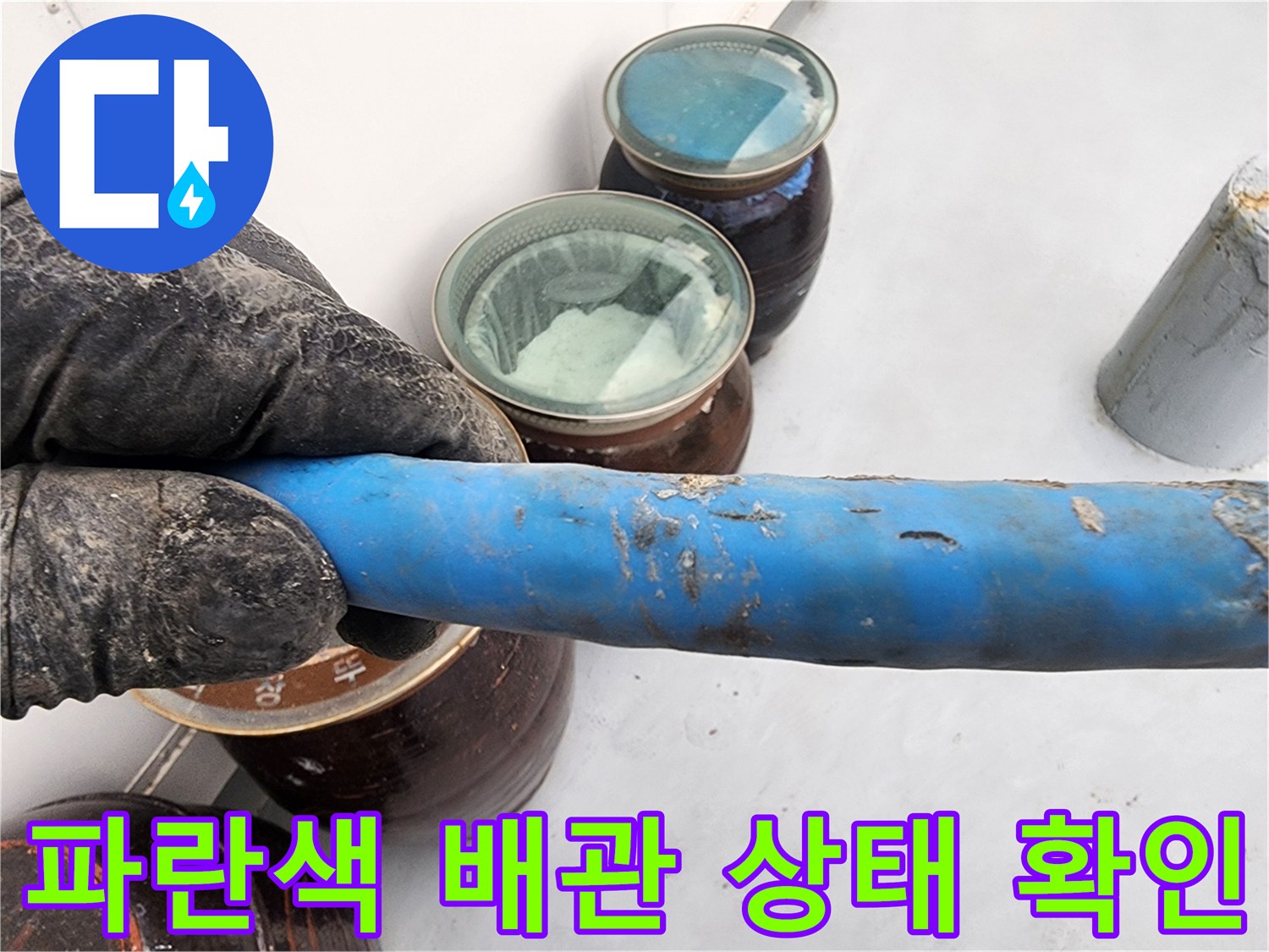파란색 보온재로 덮인 배관의 표면 상태를 점검하는 모습