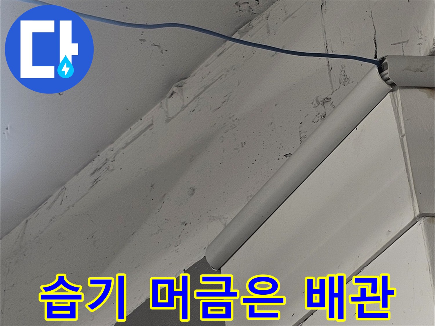 천장 마감재 아래 설치된 검은색 배관의 연결 상태입니다.