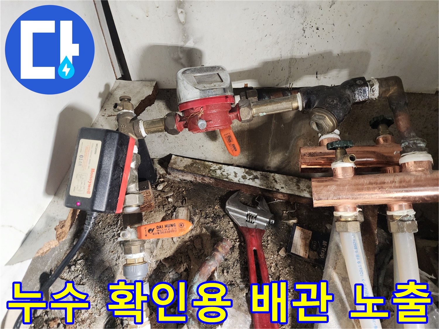 싱크대 아래쪽의 복잡한 수도 밸브와 배관 연결 상태